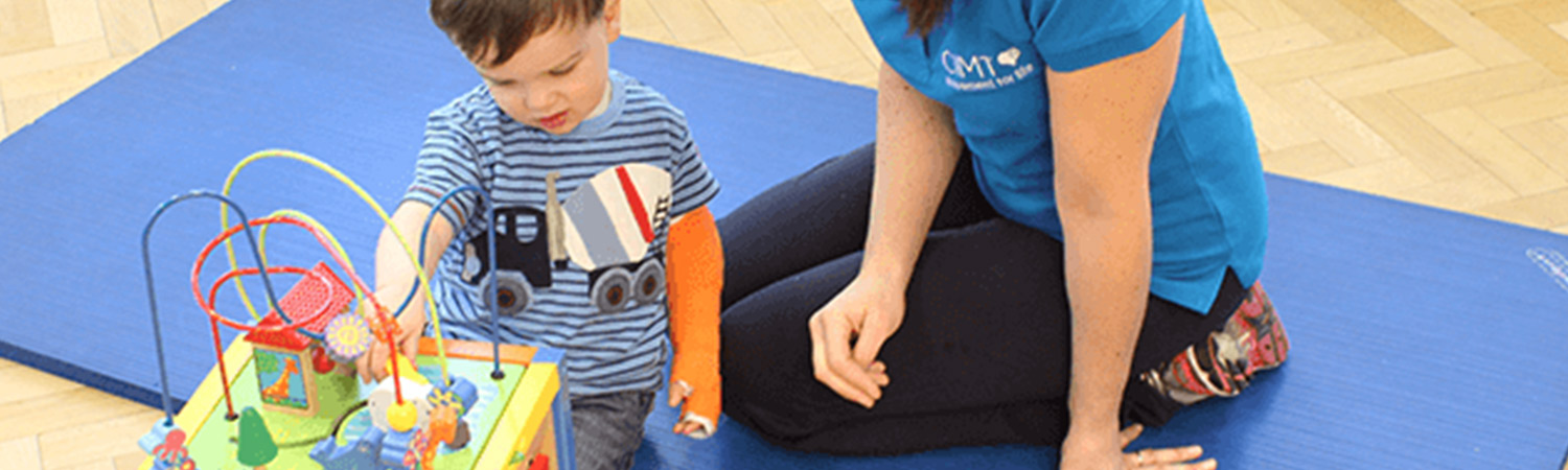 CIMT child playing with a bead train toy with their personal physiotherapist