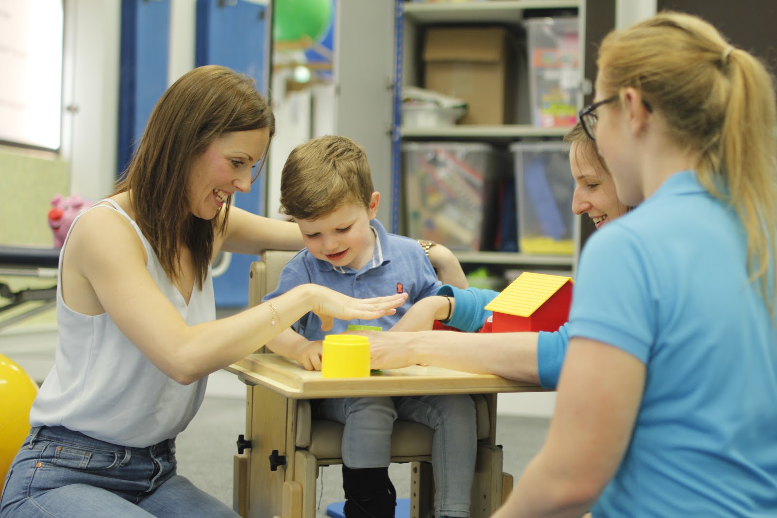 Finlay being guided by their parents through CIMT therapy.