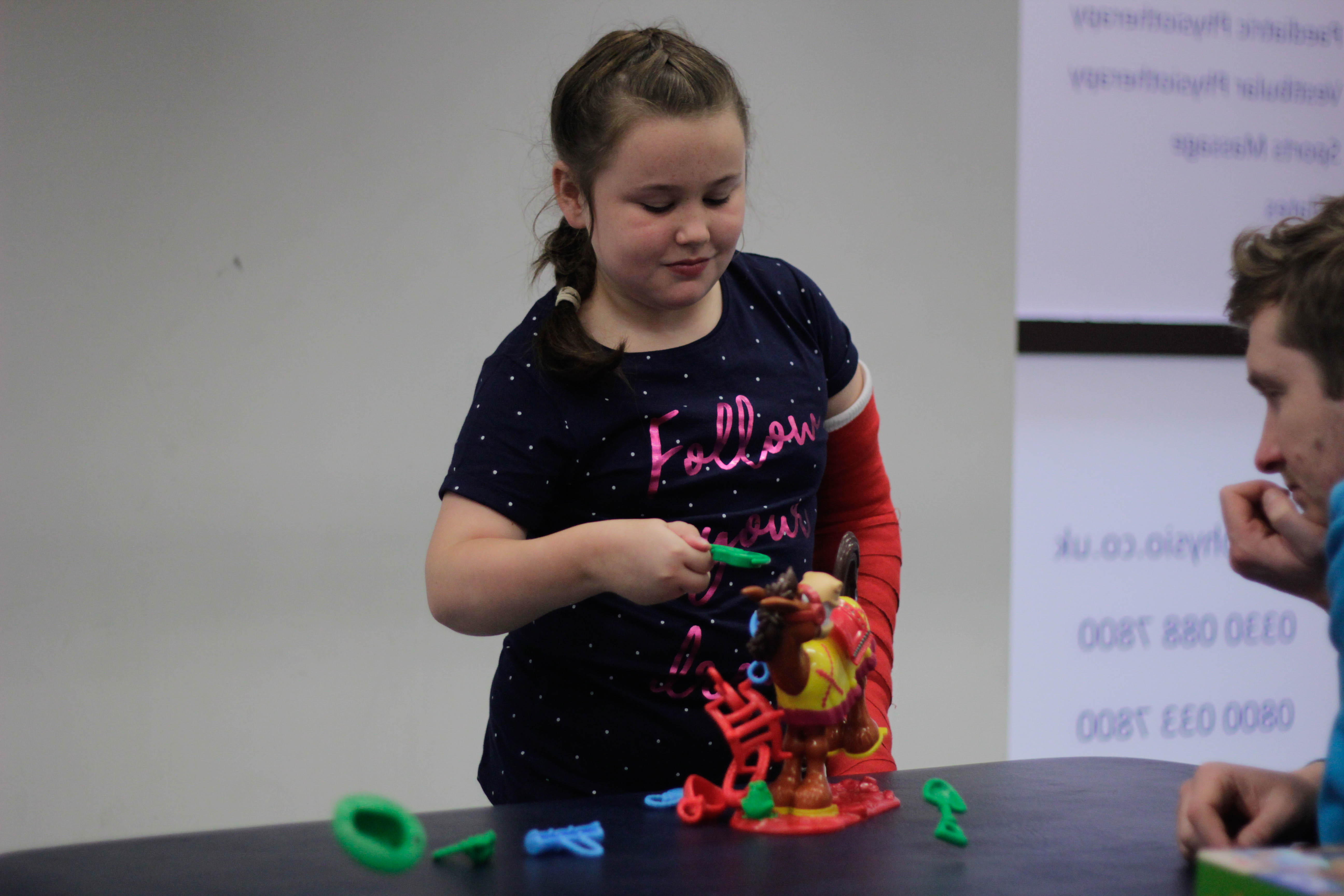 Katie bieng shown how to use the toys during CIMT treatment