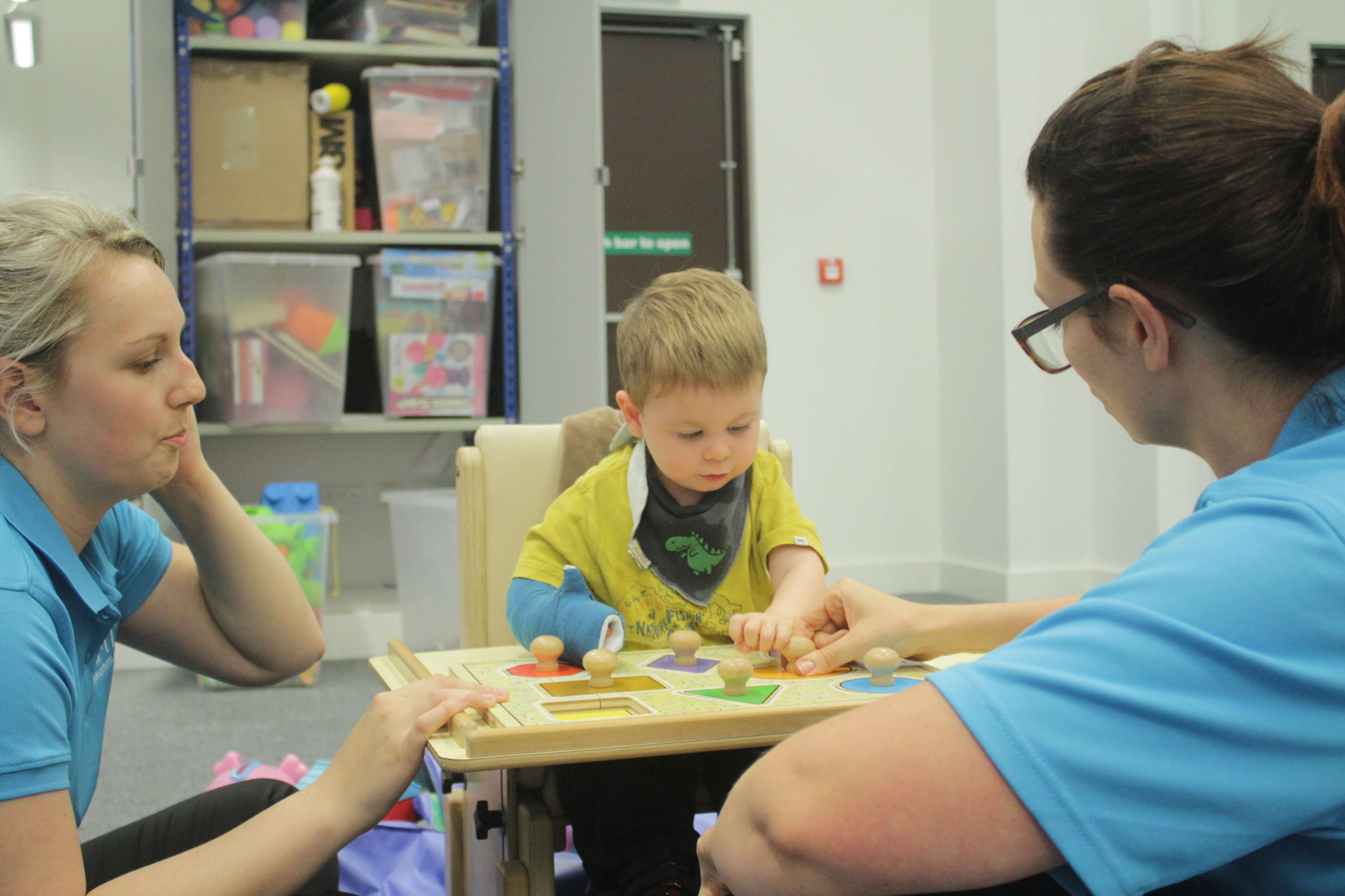 Thomas playing with shape blocks with CIMT therapists