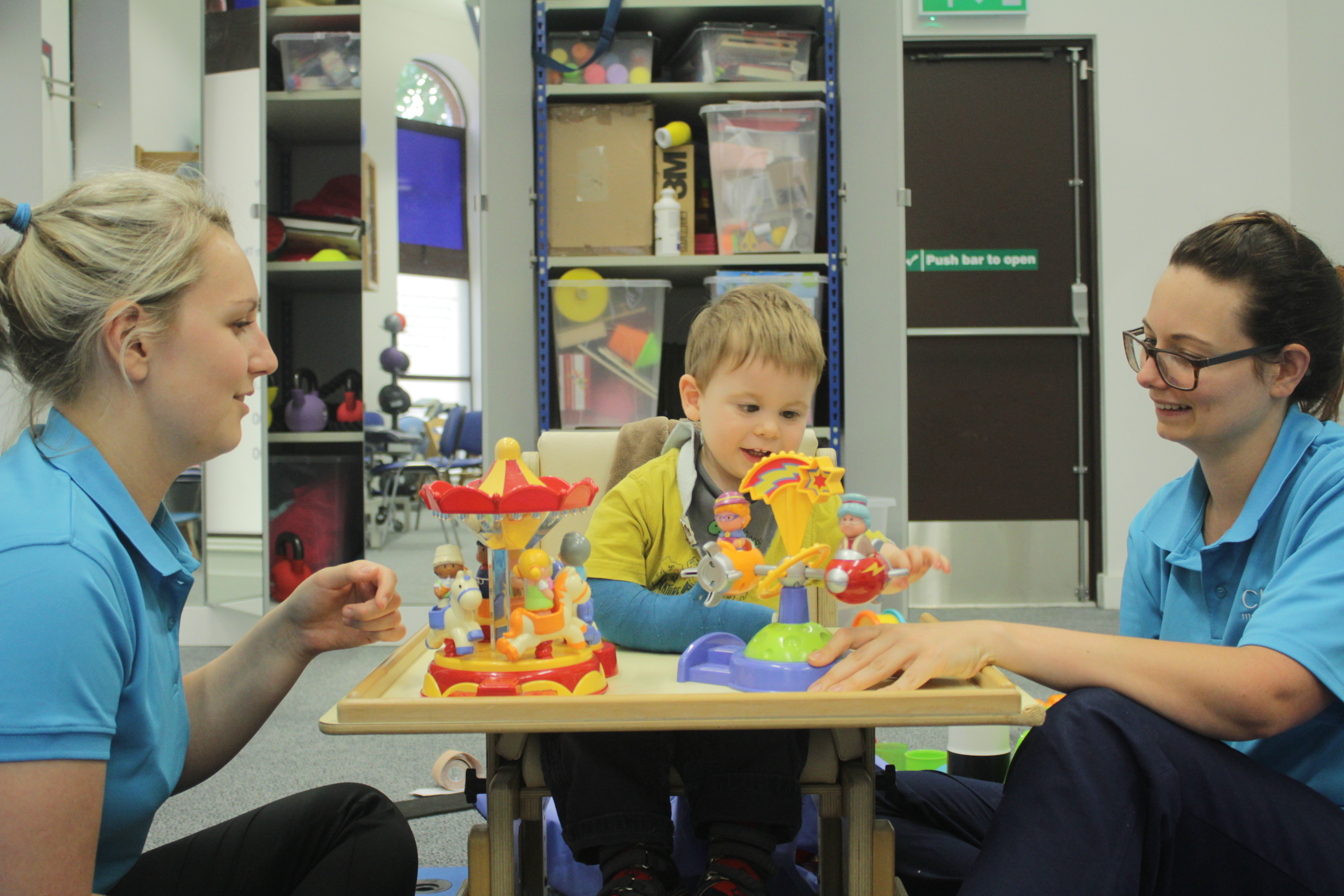 Thomas playing with toys with CIMT therapists.