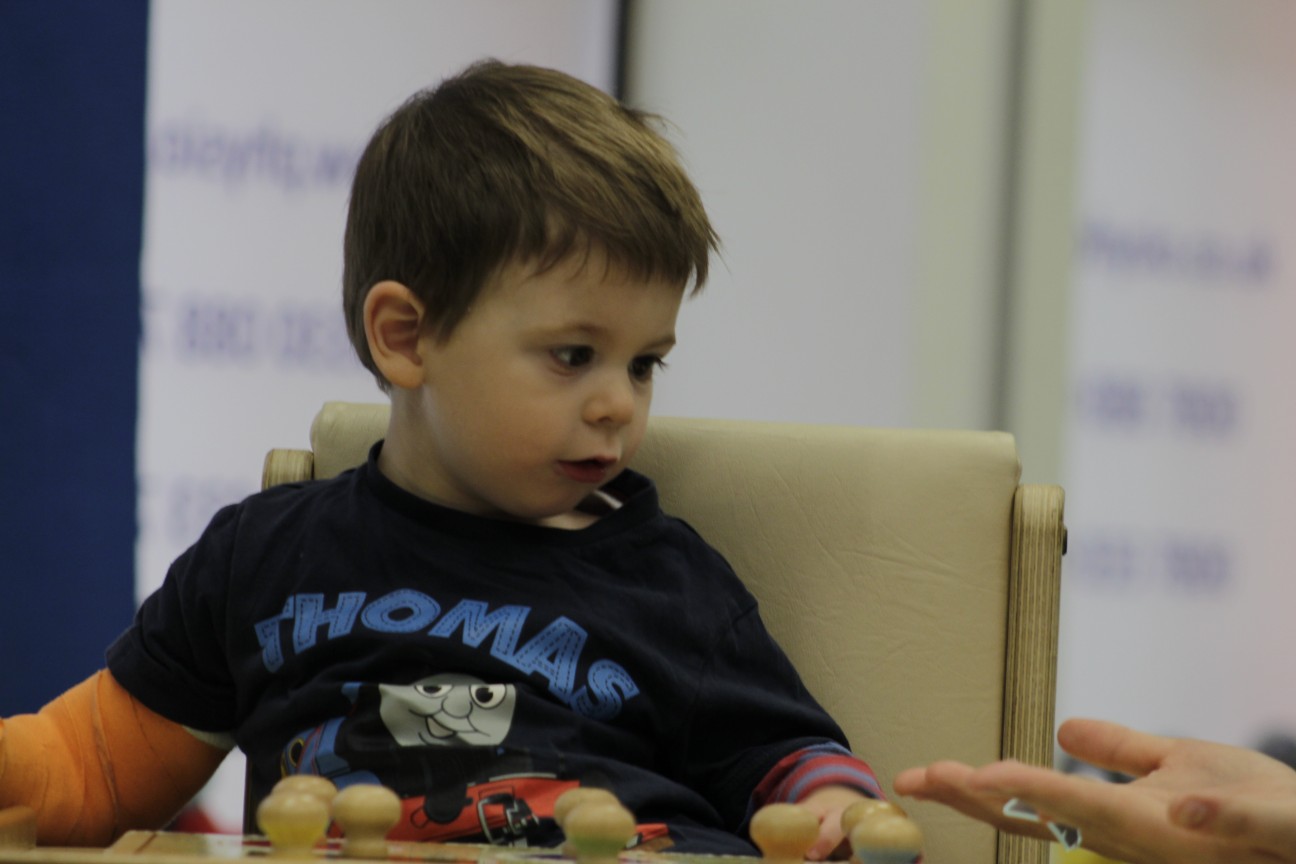 Thomas bieng shown how to use the toys during CIMT treatment