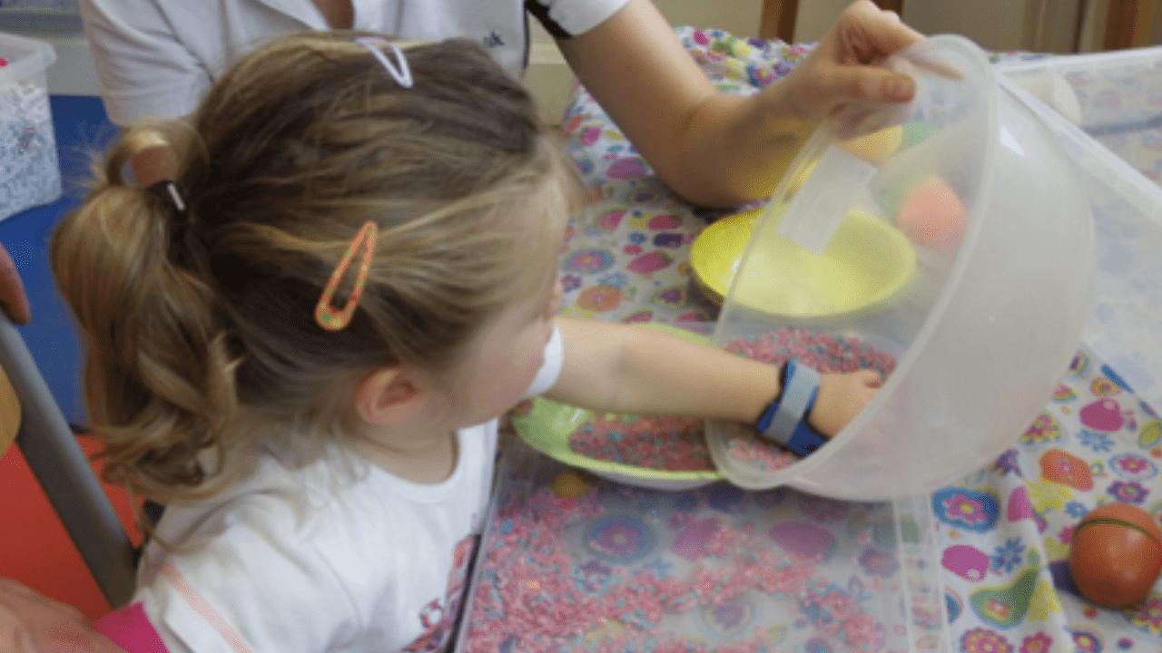 Olivia plays with mixing bowl during therapy.
